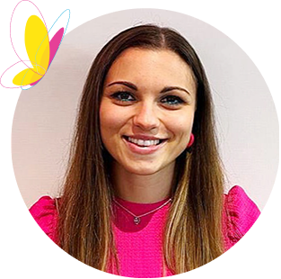 Smiling young woman with long brown hair, blue eyes, wearing a vibrant pink top.