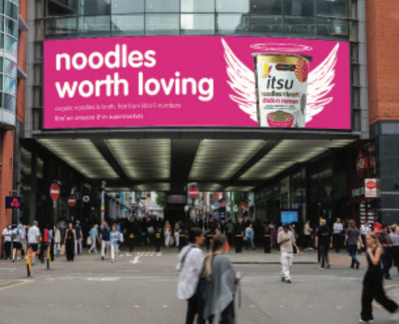 Large digital billboard advertising "itsu noodles worth loving" above a bustling city street.
