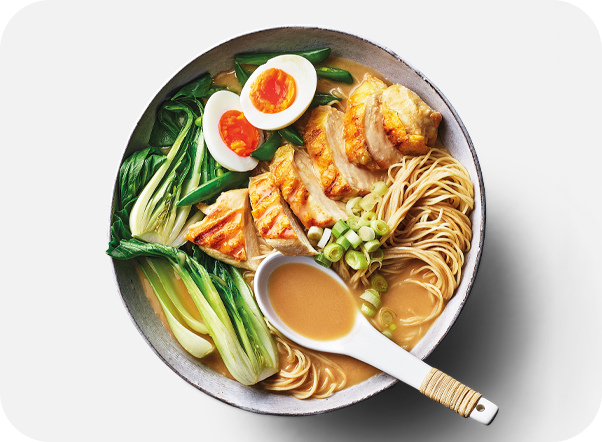 Overhead view of a delicious ramen bowl with chicken, egg, bok choy, and noodles.