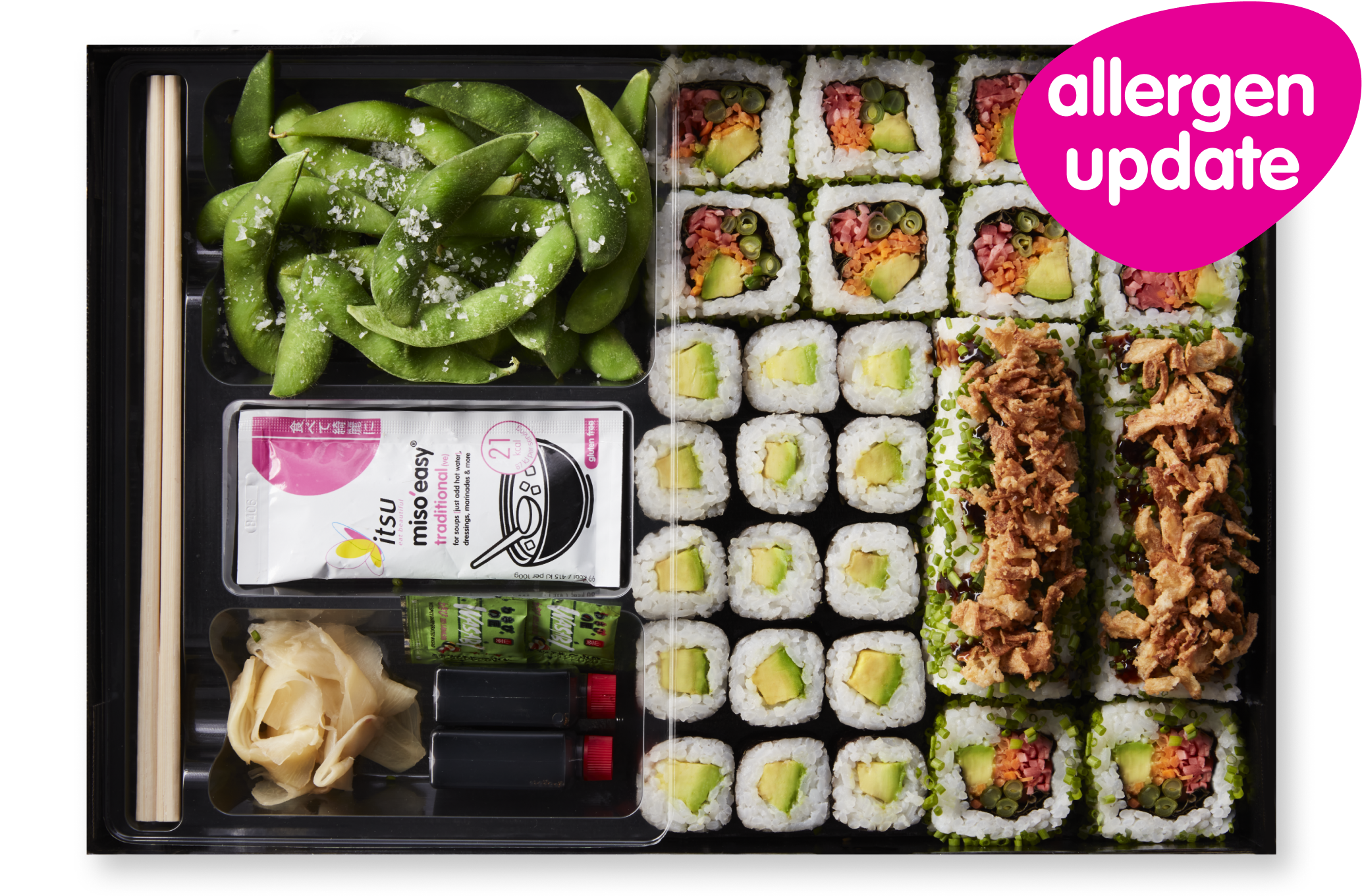 A black platter filled with various sushi rolls, edamame, sauces, and a pink 'allergen update' tag.