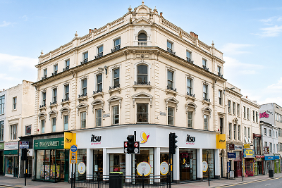 Ornate cream building with corner architecture housing an 'isu' store at ground level.