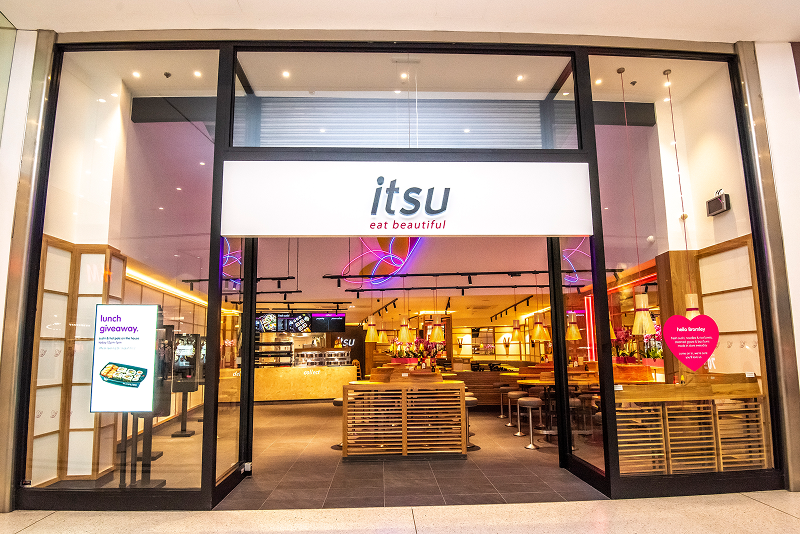 itsu restaurant storefront with 'eat beautiful' slogan, featuring a modern, brightly lit interior.