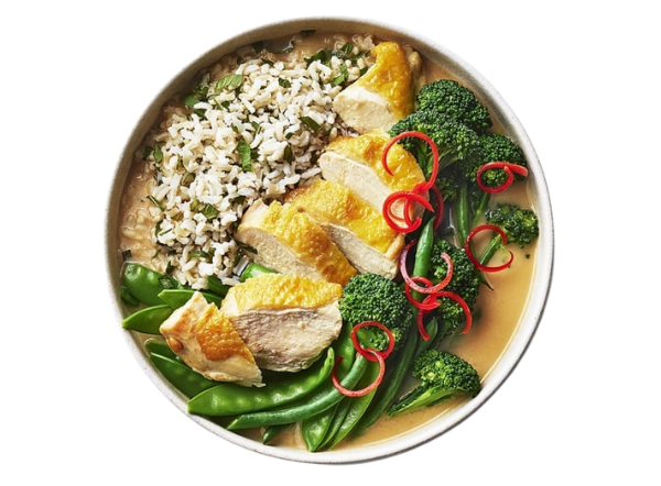 Sliced chicken breast, herbed rice, green beans, broccoli, and red chili in a bowl.