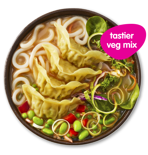 Bowl of udon noodle soup with dumplings, vegetables, and a 'tastier veg mix' sticker.