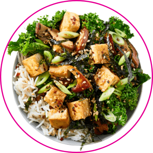 A vibrant bowl of rice, crispy tofu, kale, broccoli, mushrooms, and green onions.