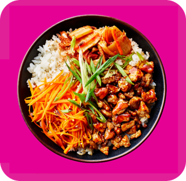 Bowl of rice with teriyaki chicken, kimchi, shredded carrots, and green onions.