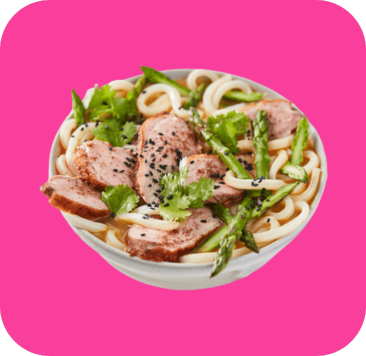 Udon noodle soup with sliced duck, asparagus, cilantro, and black sesame seeds.