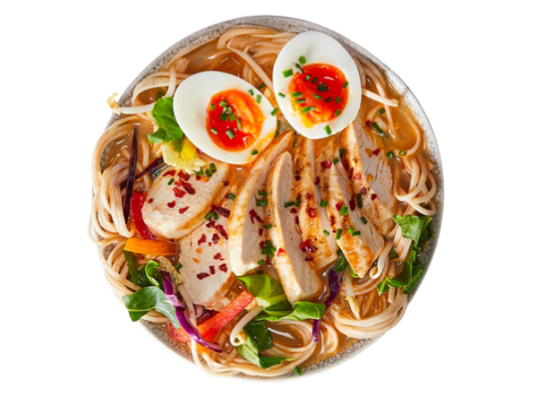A bowl of chicken ramen with noodles, two halved boiled eggs, and fresh vegetables.