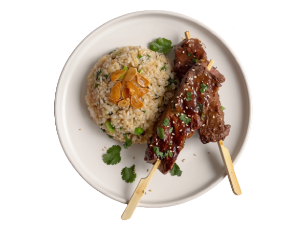 Two glazed beef skewers with sesame and herbs, served with savory fried rice.