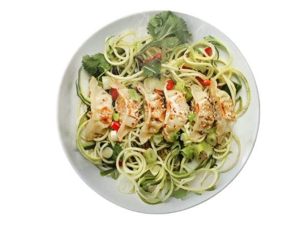 A plate of zucchini noodles topped with grilled dumplings, red peppers, and greens.