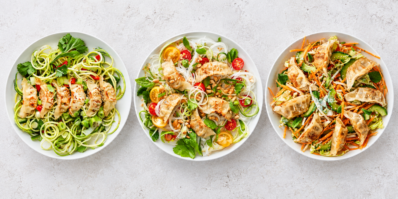 Three bowls of Asian-inspired meals with dumplings, zucchini noodles, and fresh vegetables.