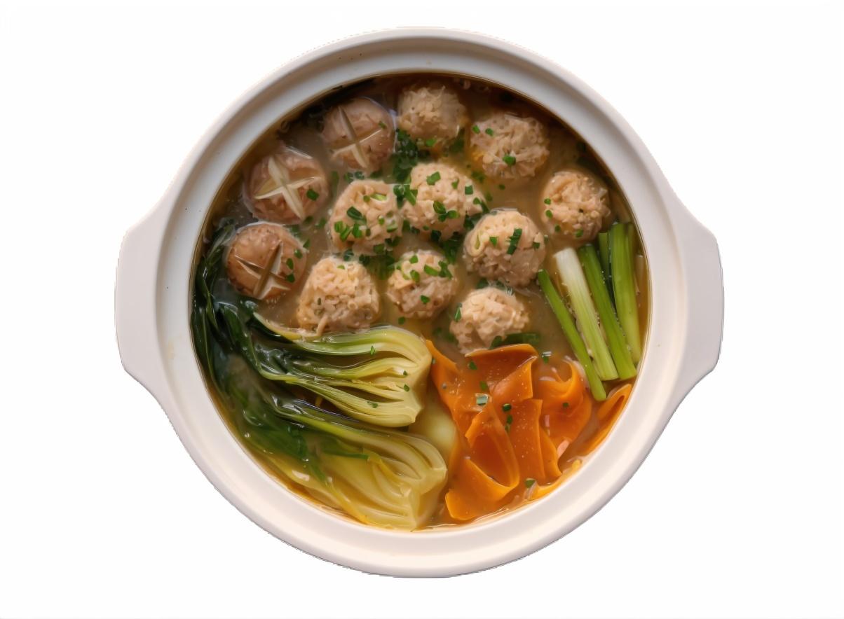 White pot of soup with meatballs, bok choy, carrots, and mushrooms.
