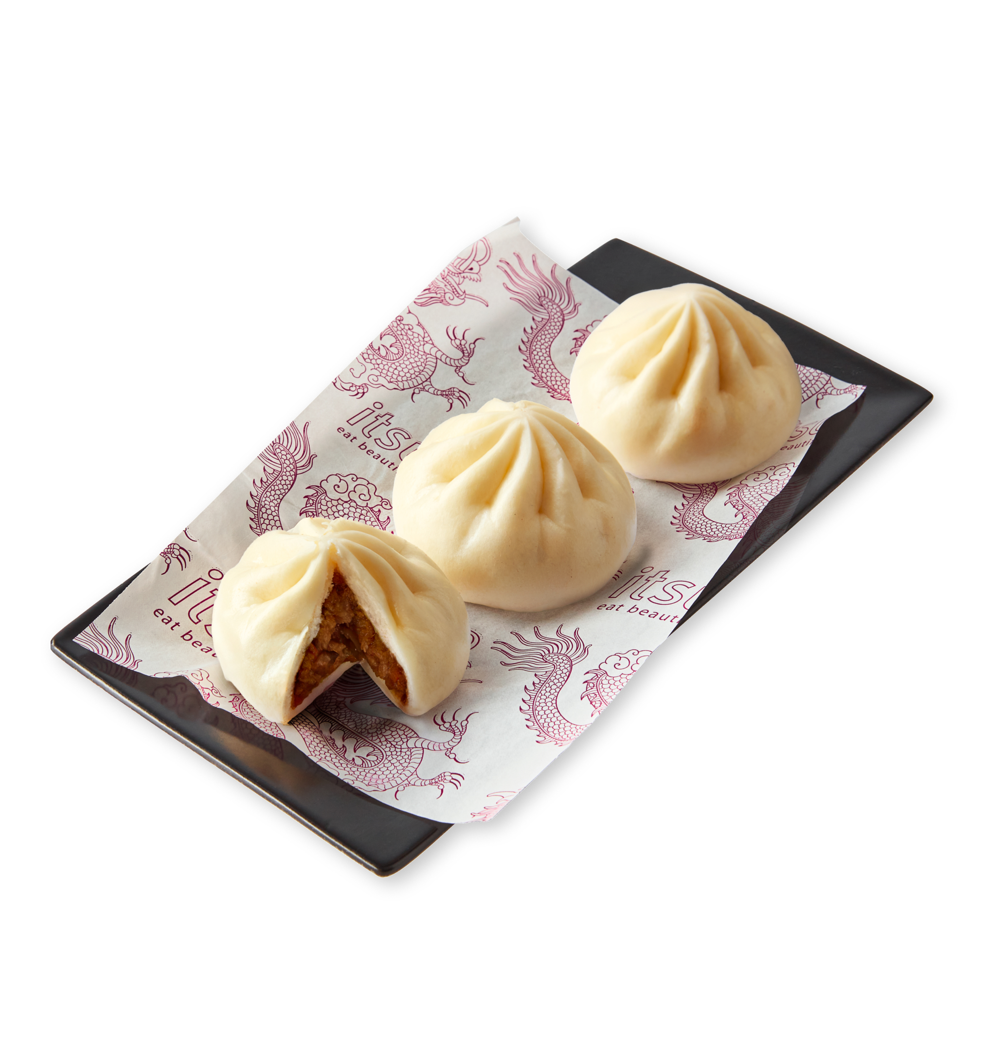 Three steamed buns on a black plate, one cut open revealing savory filling.