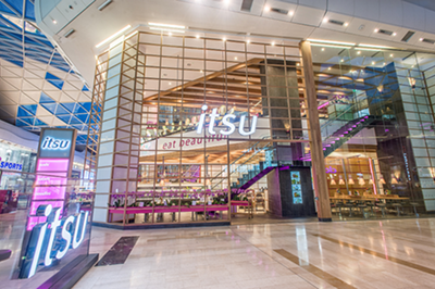Modern itsu restaurant with large glass windows and prominent signage inside a bright building.