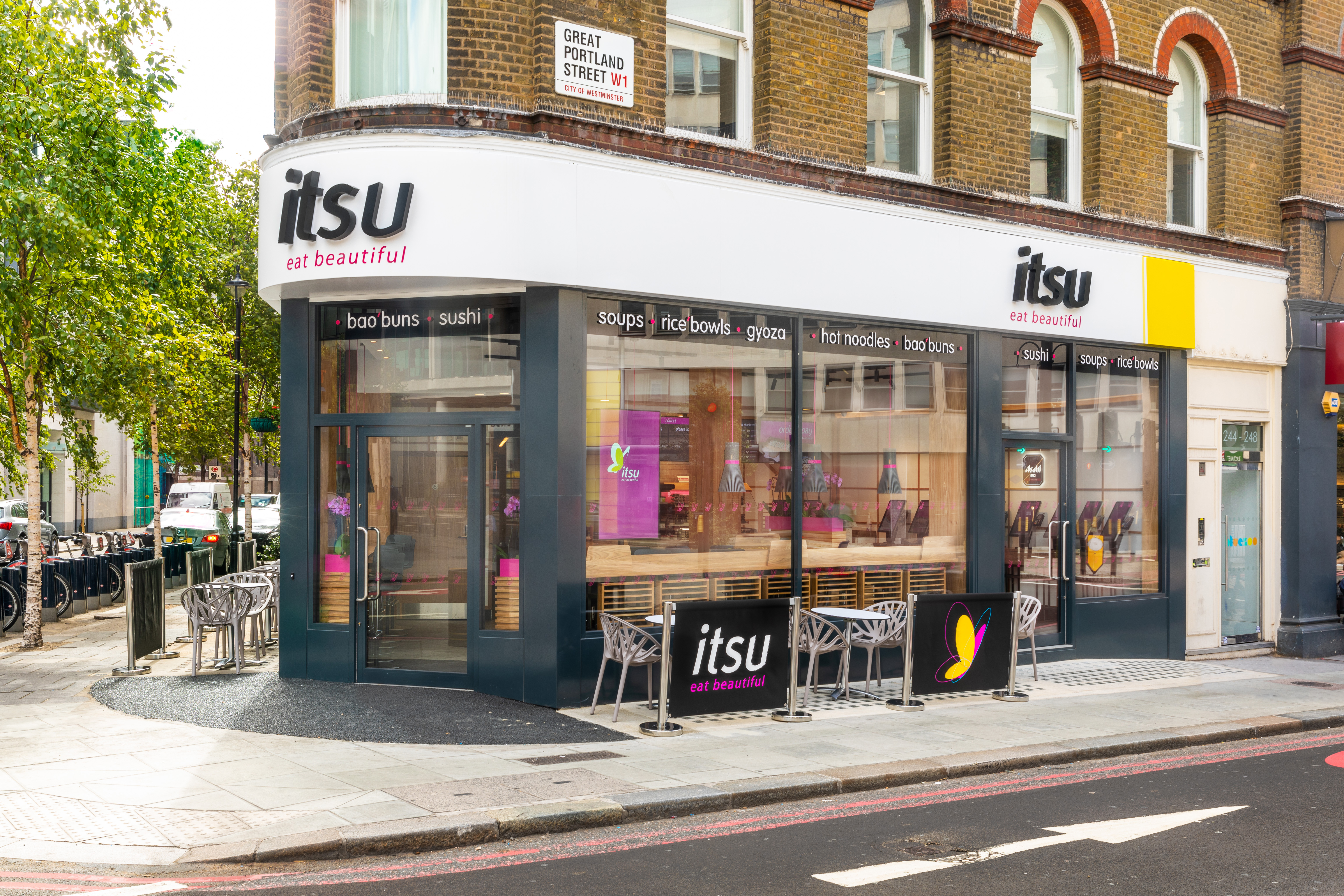 Corner view of an itsu sushi and salad bar with outdoor seating.