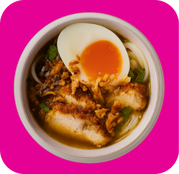 Bowl of ramen with crispy fried chicken, soft-boiled egg, noodles, and fried shallots.