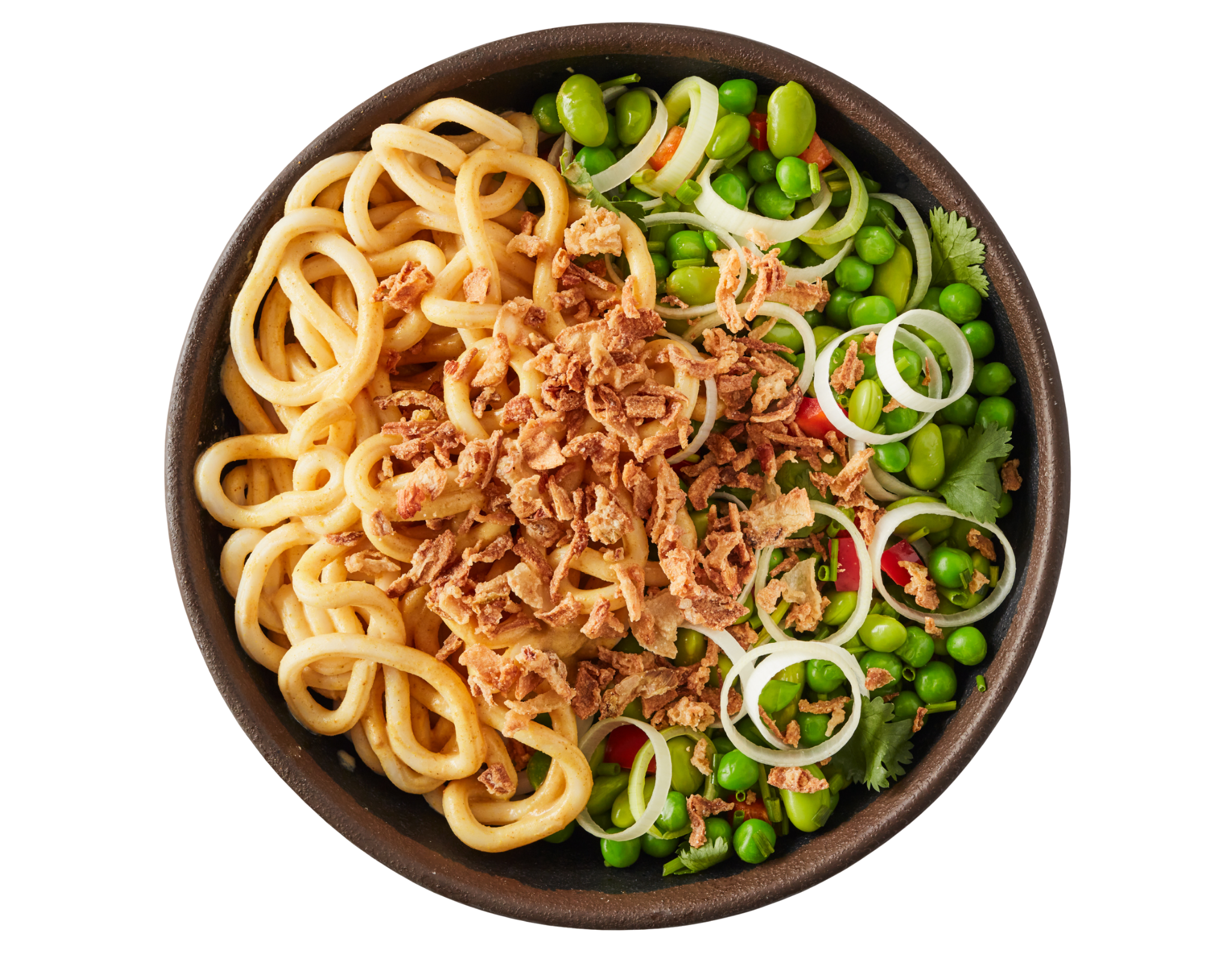 Udon noodle bowl with fried onions, green peas, edamame, and sliced spring onions.