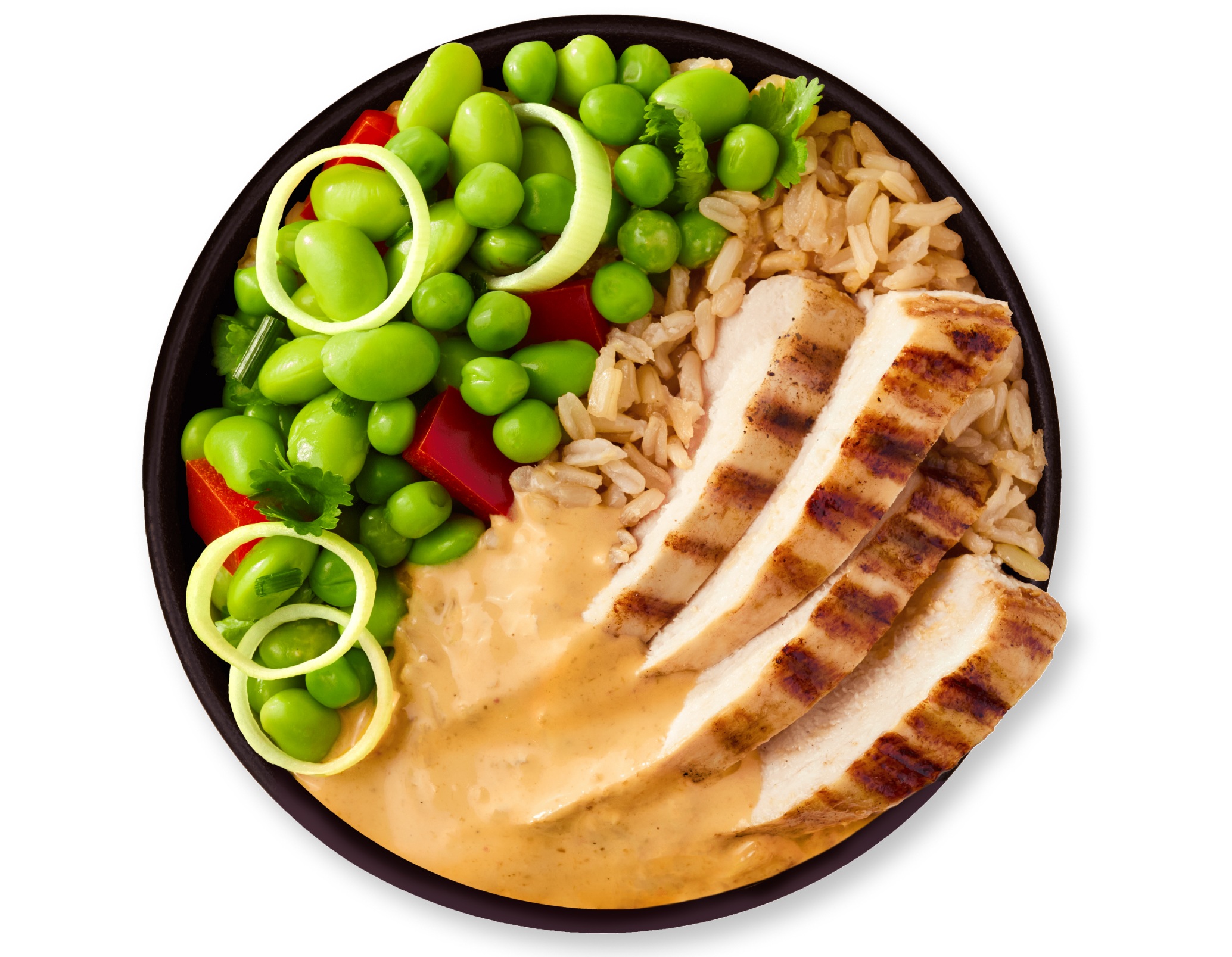Grilled chicken, edamame, and rice bowl with hummus and sliced onions.