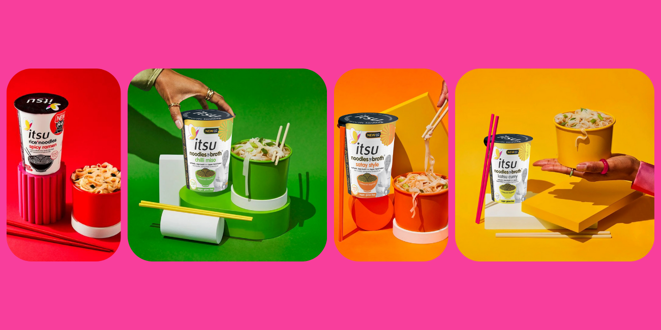 Red instant noodle cup on cylindrical stand with separate noodles and chopsticks.