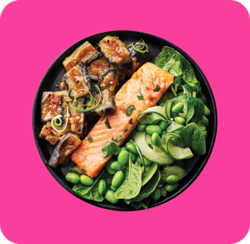 Bowl with cooked salmon, edamame, spinach, and grilled eggplant, garnished with herbs.