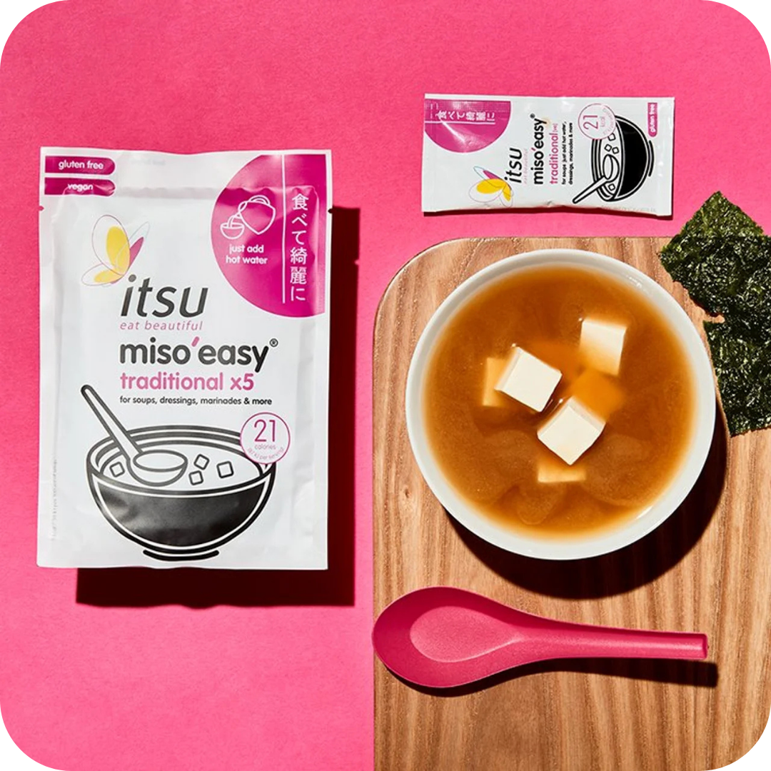 Bowl of miso soup with tofu, next to an 'itsu miso'easy' instant soup packet.