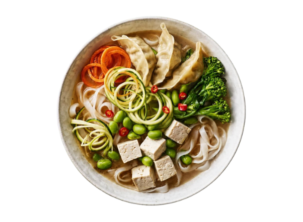Asian noodle soup bowl with dumplings, tofu, edamame, broccoli, and spiralized vegetables.