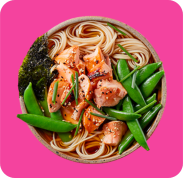 A colorful bowl of salmon and noodle stir-fry with snap peas, seaweed, and sesame seeds.