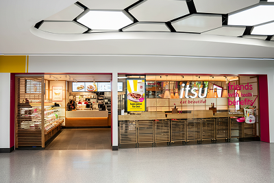 Modern itsu restaurant storefront with counter and food displays in a bright terminal.