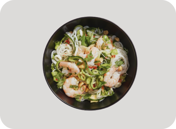 Vibrant noodle salad with succulent shrimp, fresh green vegetables, and crunchy peanuts.