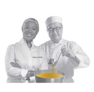 Two chefs, one smiling woman with arms crossed, and a man pouring golden liquid.