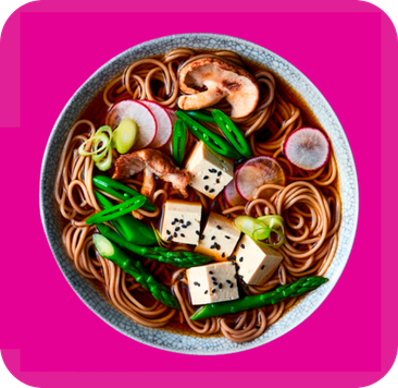 Bowl of soba noodles with tofu, shiitake mushrooms, radishes, and green asparagus.