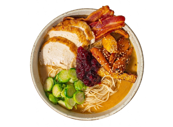 Thanksgiving-themed ramen bowl with sliced turkey, crispy bacon, cranberry, and roasted vegetables.