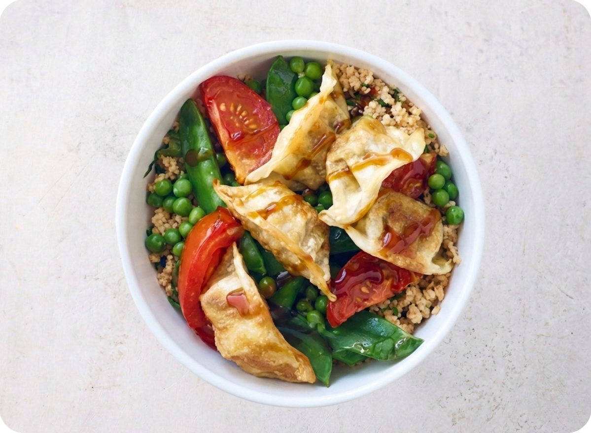Bowl of ground chicken, peas, tomatoes, and fried dumplings drizzled with sauce.