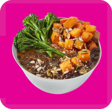 Bowl of dark grains, roasted sweet potatoes, broccoli, and a sprinkle of seeds.
