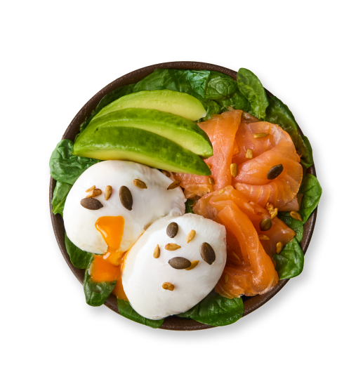 Poached eggs, smoked salmon, avocado, and greens in a bowl, eggs creatively decorated.