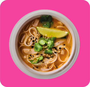 Noodle soup with chicken, lime, cilantro, and sesame seeds in a white bowl.