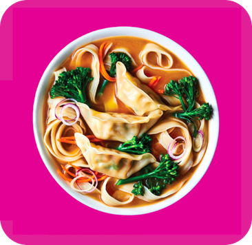Soup with noodles, three dumplings, broccoli, carrots, and red onions in a white bowl.