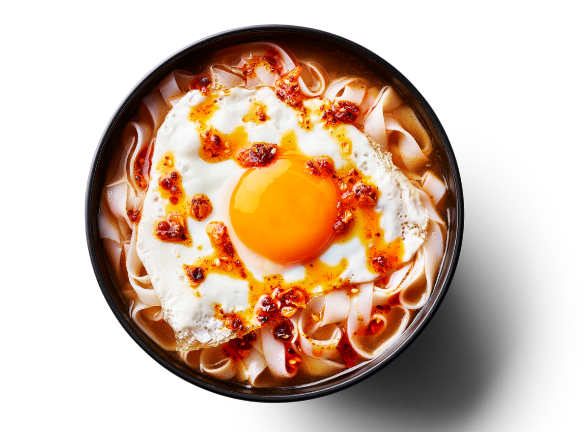 Flat noodles in broth topped with a sunny-side up egg and vibrant red chili oil.