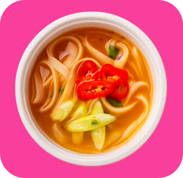 A vibrant bowl of spicy noodle soup with red chili and green onion.