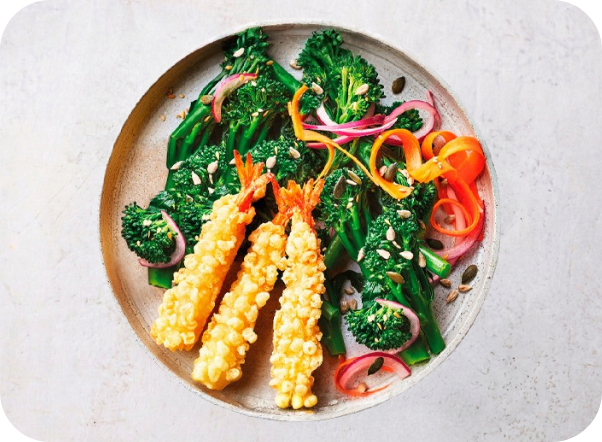Crispy tempura shrimp served with vibrant green broccoli, red onion, and julienned carrots.