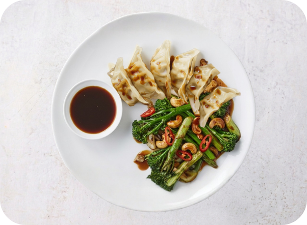 Pan-fried dumplings and stir-fried broccolini with cashews, chili, and soy dipping sauce.