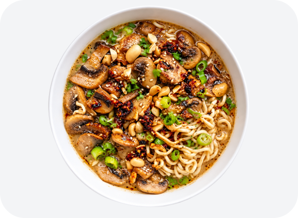 Spicy ramen noodles topped with mushrooms, chicken, green onions, and crunchy peanuts.