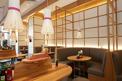 Modern restaurant interior with wooden tables, gray booths, and unique white pendant lights.